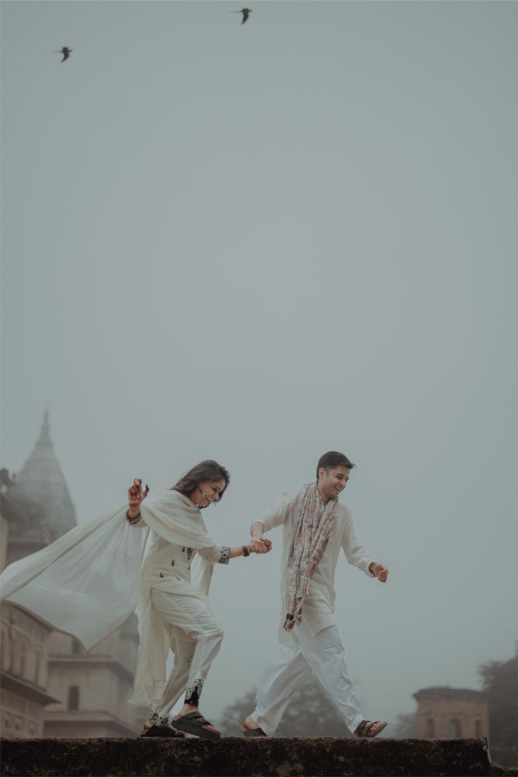 White kurta sets with dupatta against misty temple architecture