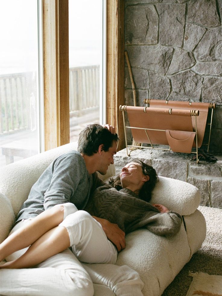 Soft laughter on a stone-and-linen sofa by the window