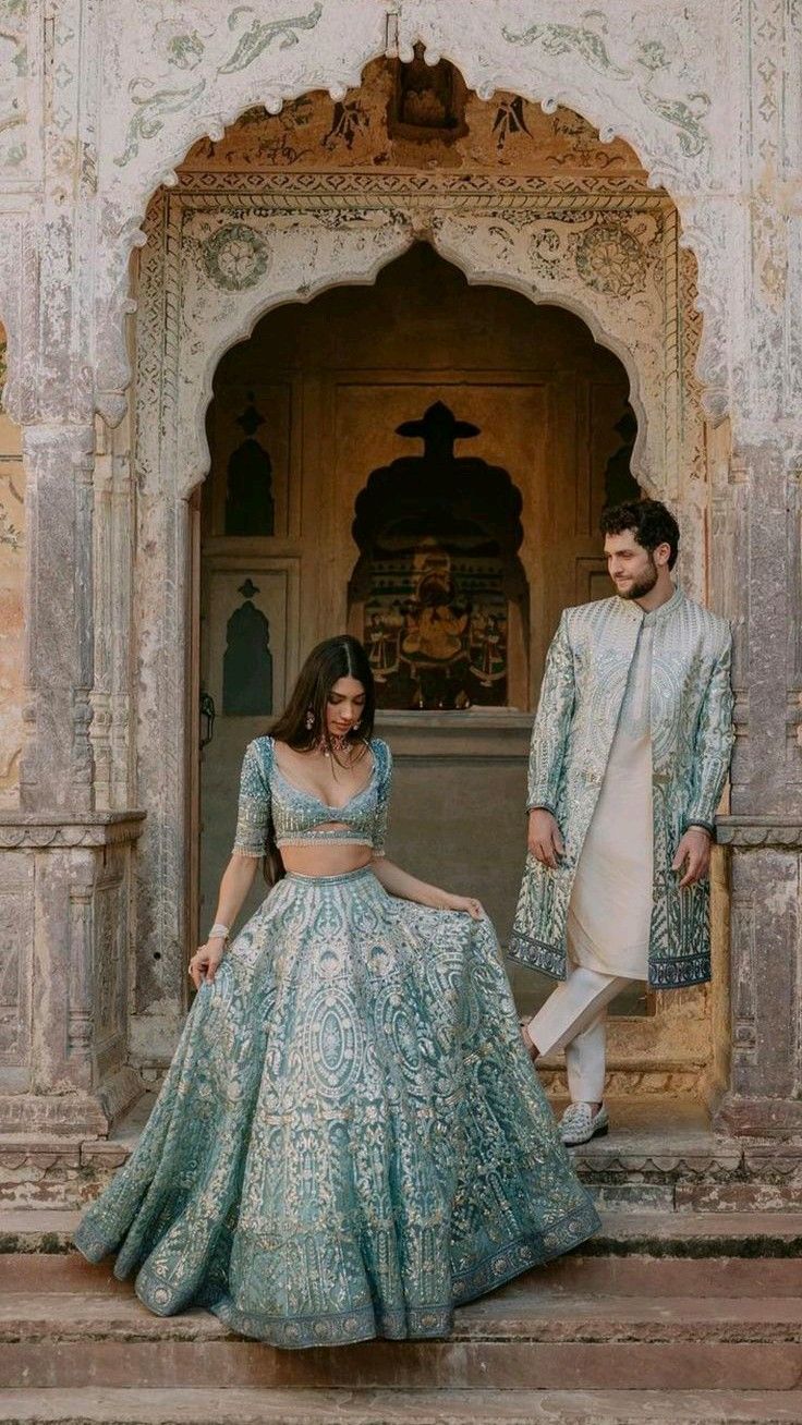 Powder blue lehenga and matching sherwani at carved heritage doorway