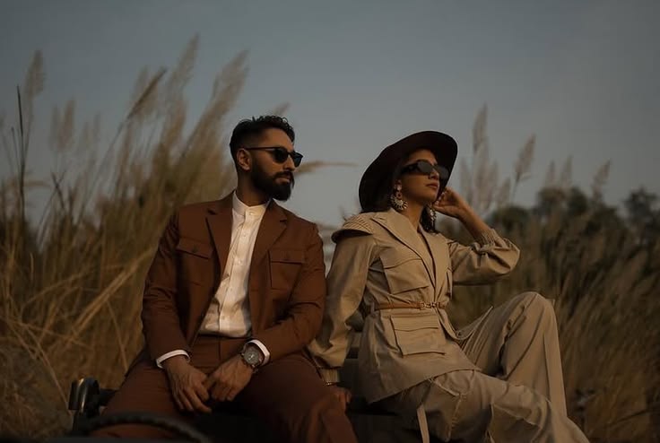 Tailored brown and taupe safari layers seated in tall golden grass