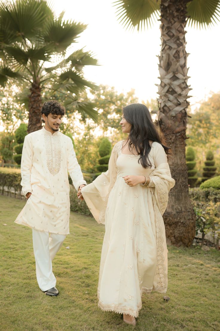 Ivory embroidered anarkali and kurta in a palm garden at sunset