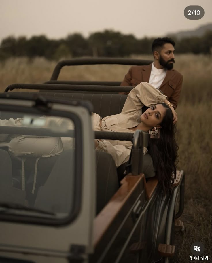 Beige shirtdress and rust suit reclining on a safari jeep
