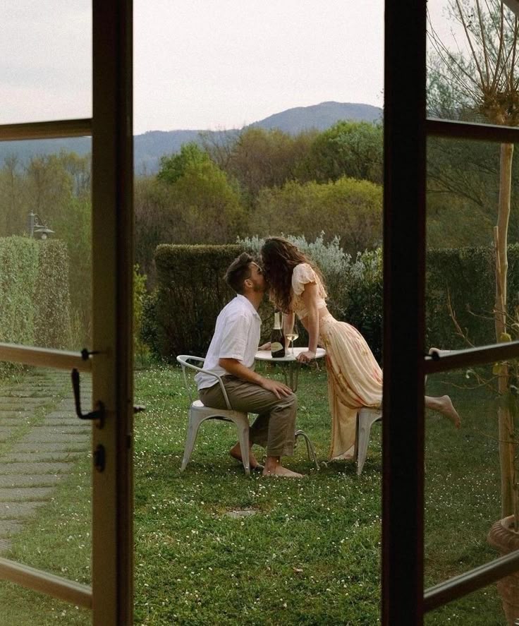 Garden kiss through French doors in soft peach dress