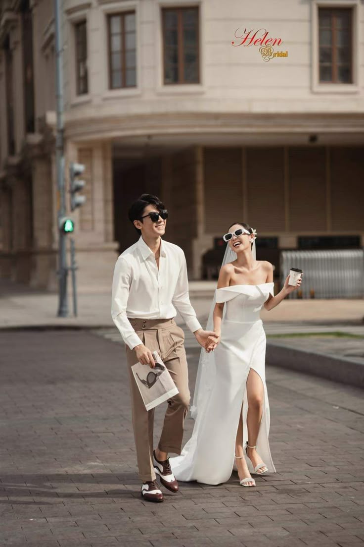 White shirt and taupe trousers with an off-shoulder column gown, city street