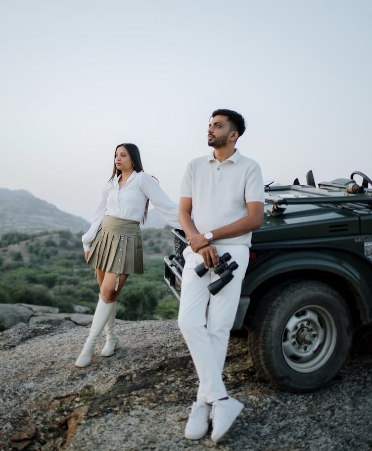 White shirt and olive pleated skirt with a white polo set against a mountain jeep