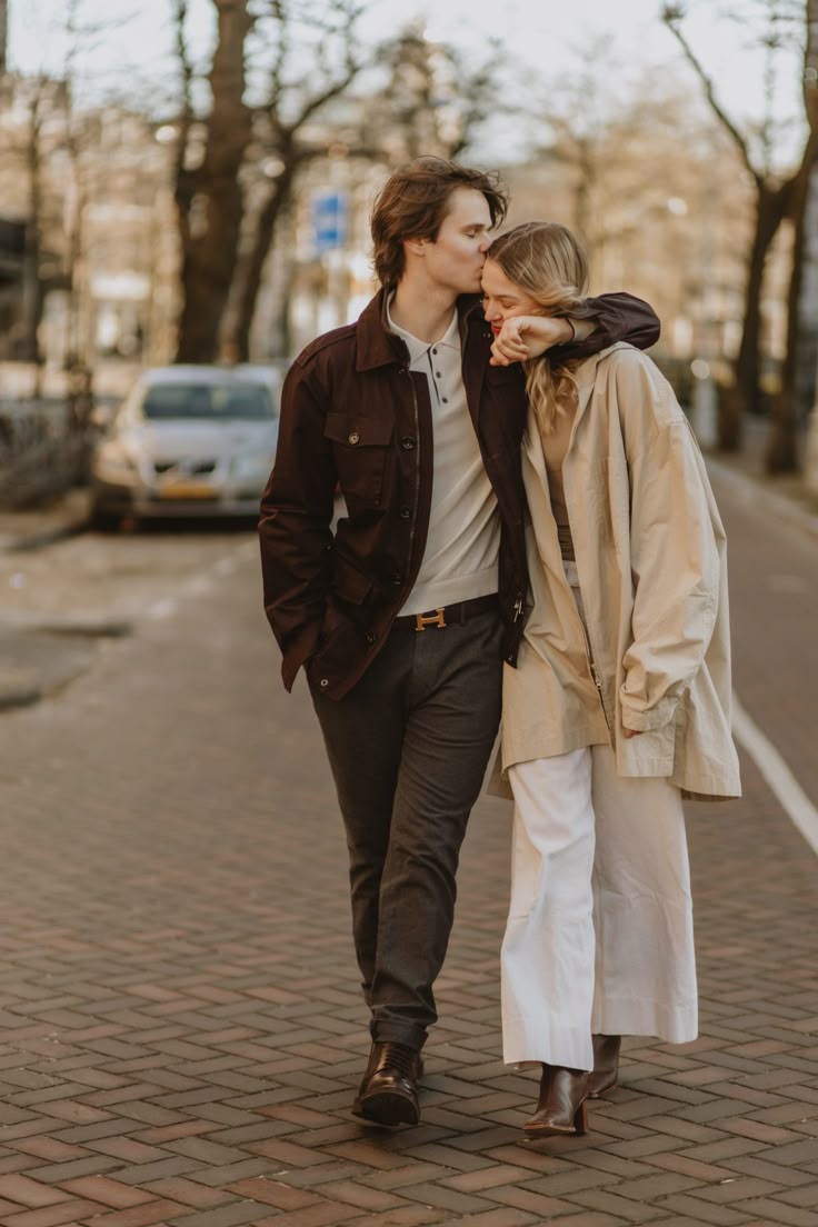 Chocolate jacket and beige trench coat on a brick city street