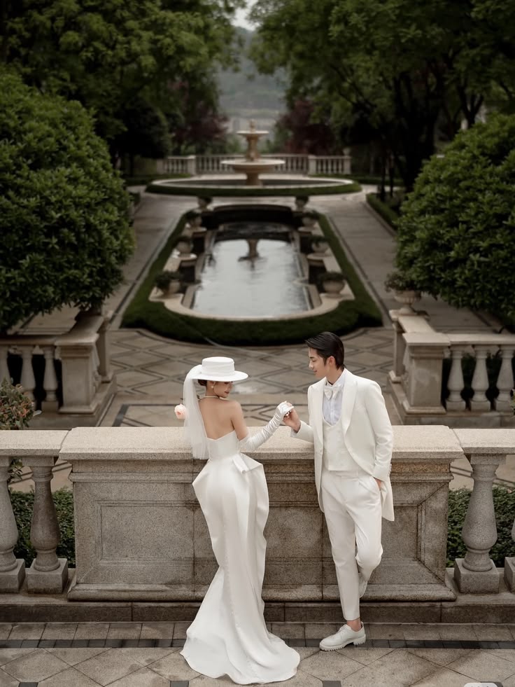 Ivory tuxedo with a satin gown and wide-brim hat on a formal terrace